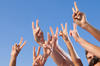 multiple hands in the air giving the peace sign multiple hands in the air giving the peace sign