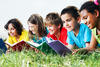 line of kids lying in the grass reading books line of kids lying in the grass reading books