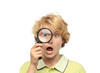 Boy looking through magnifying glass with surprised look on his face Boy looking through magnifying glass with surprised look on his face