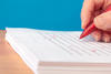 person with red pen in hand, editing a paper person with red pen in hand, editing a paper
