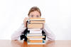girl resting head on stack of books girl resting head on stack of books