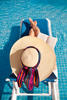 Woman lounging by the pool reading a book Woman lounging by the pool reading a book